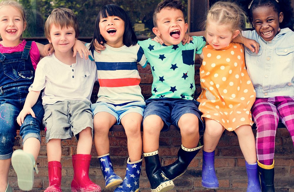 Group of kindergarten kids friends arm around sitting and smilin