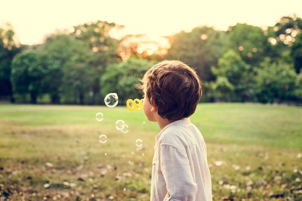 Children is playing bubbles in a park