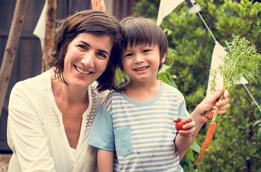 A child in a garden with carrot