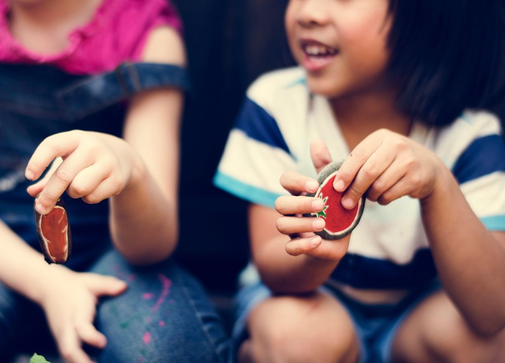 Little Kids Hands Holding Painted Rock Talking Together
