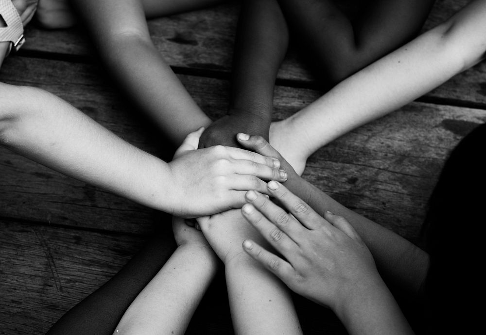 Black and white image of children's hands together