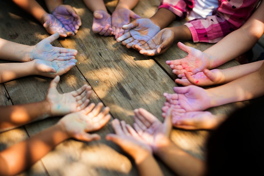 Diverse group of children playing with dirt on their hands