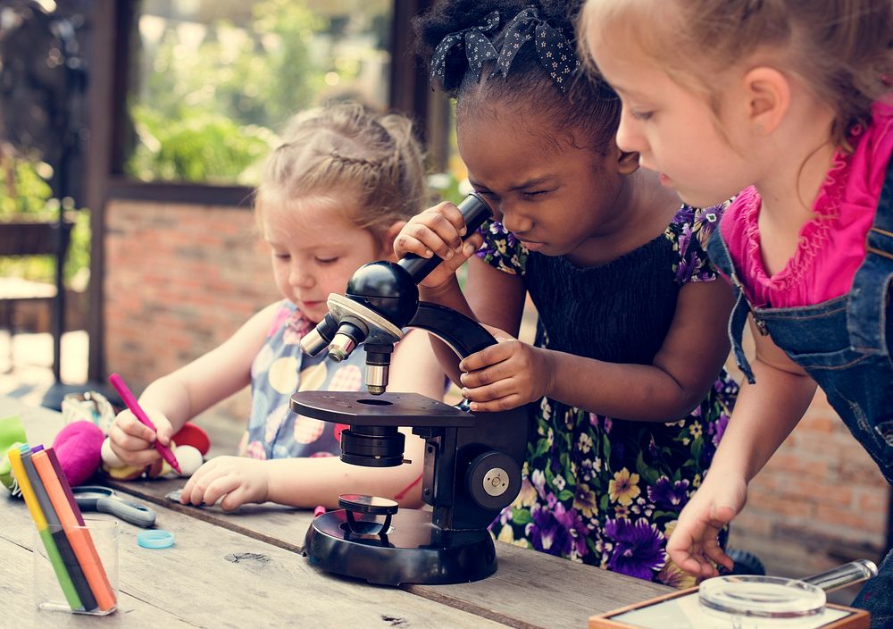 Little Girls Using Microscope Learning Science Class