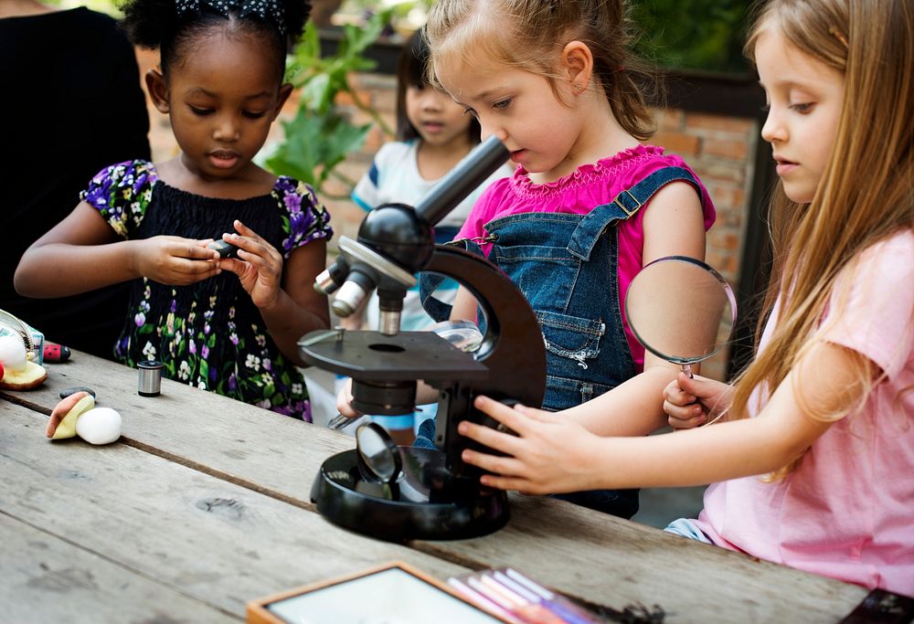 Group of children learning science by microscope
