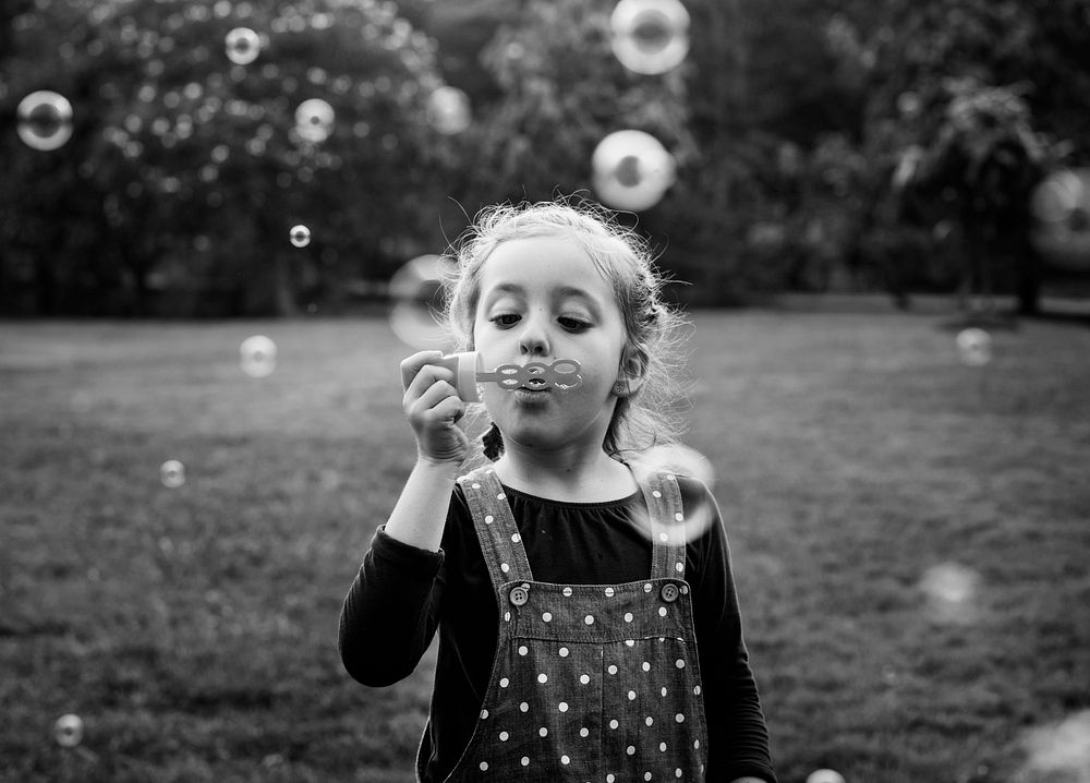 Little girl playing with bubbles