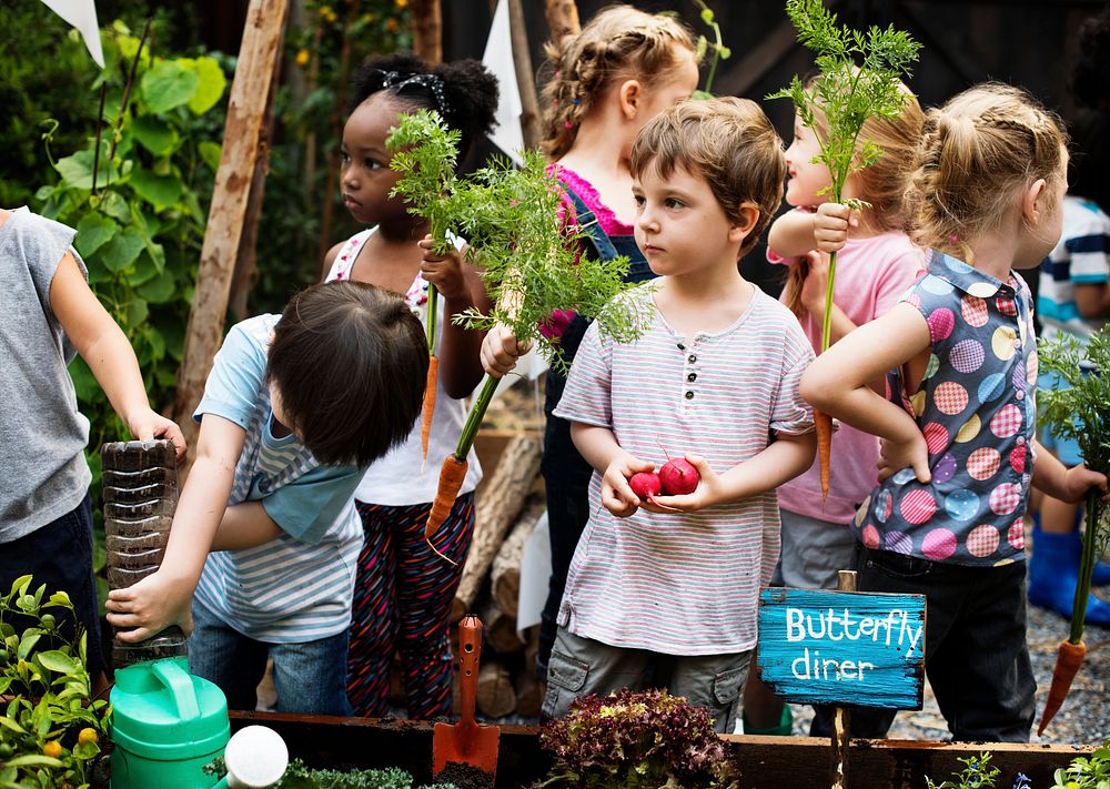 Diverse group of children learning how to plant