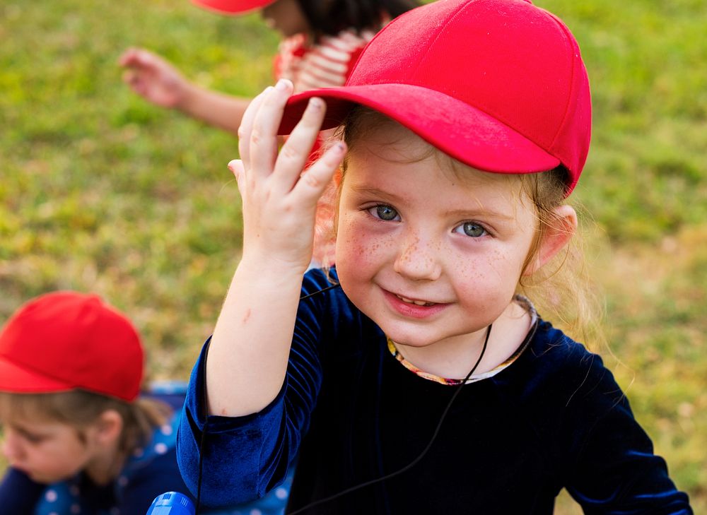 Girl with red cap is smiling to camera