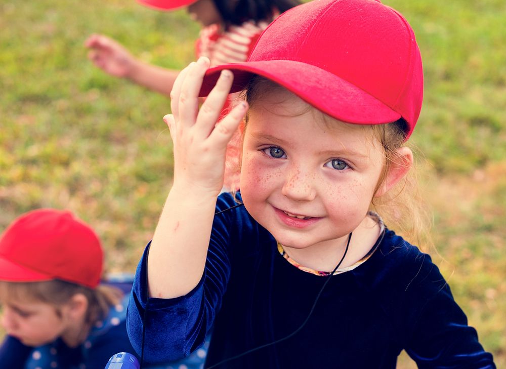 Girl with red cap is smiling to camera