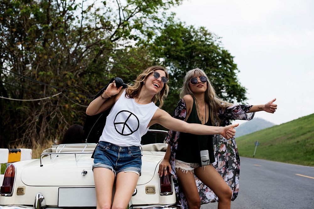 Woman Hitch Hiking on The Street Side Near The Broke Down Car