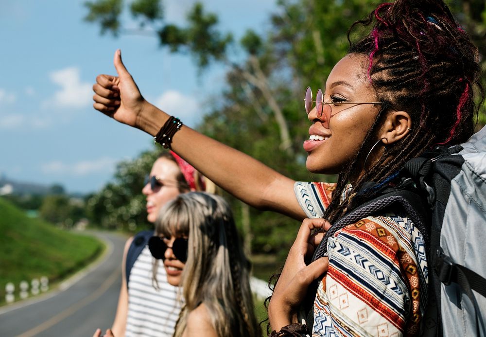 Group of Diverse Backpacker Woman Hitch Hiking on The Street Side