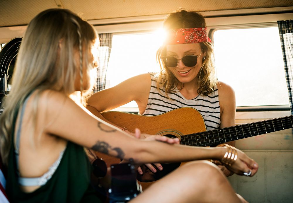Woman Playing Guitar on Road Trip with Friends Together