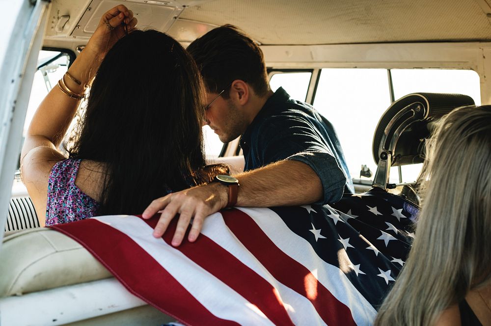 People Sitting in a Front Seat with American Flag on Rear Seat