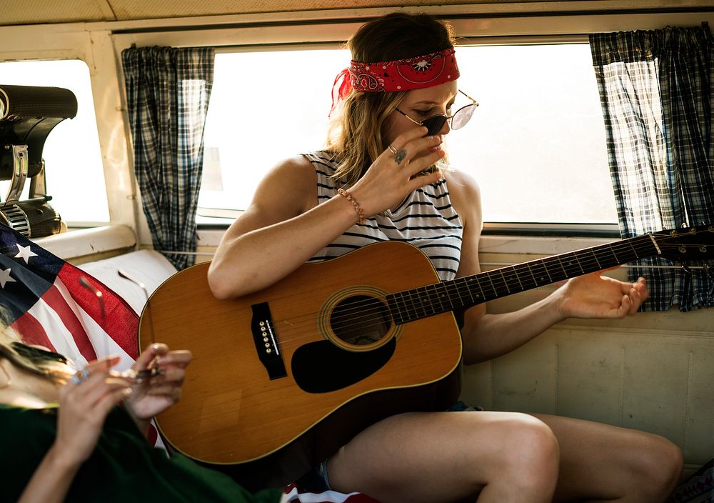 Woman Playinh Guitar on Road Trip with Friends Together