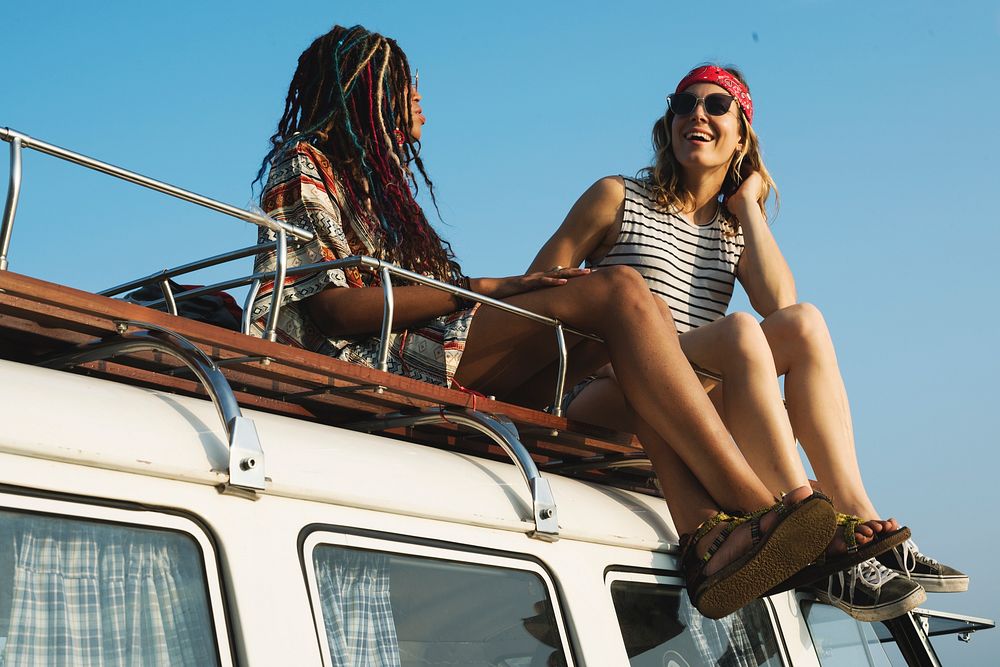 Women Sitting on The Roof of the Van Traveling Road Trip