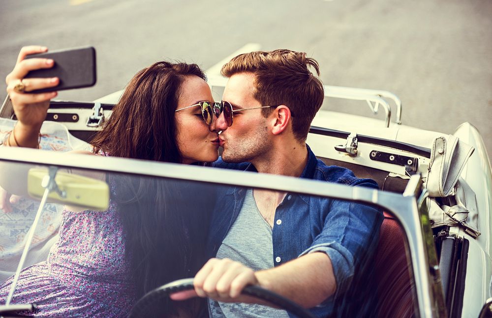 Couple Driving a Car Traveling on Road Trip Together