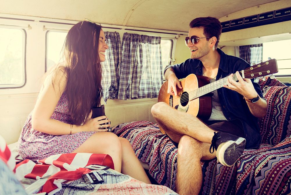 Man Playing Guitar with Woman in a Van Road Trip
