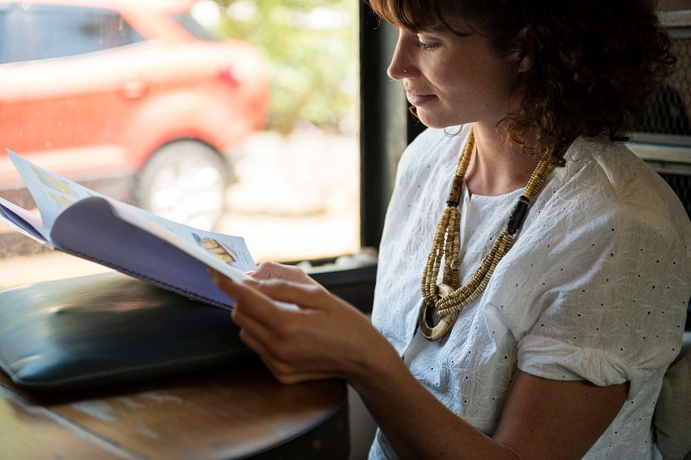 Woman reading magazine at coffee shop