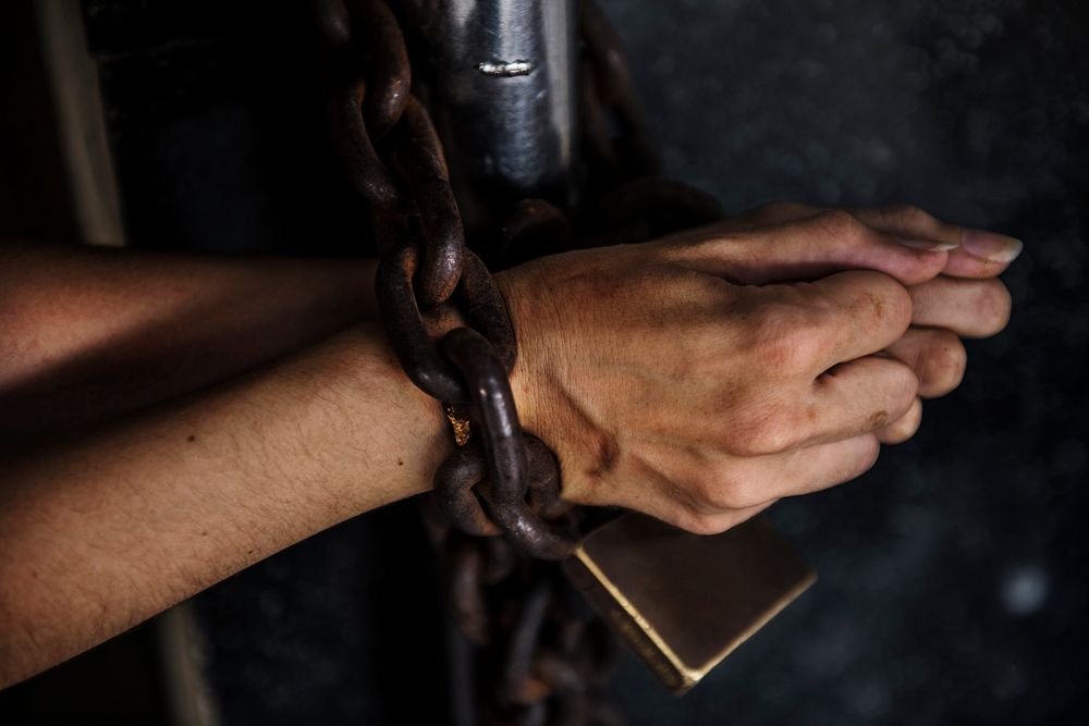 Two Hands got Chained with Padlock on Bars Prisoner