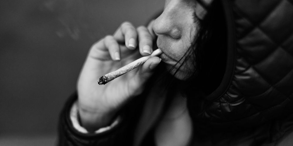 Woman smoking cigarette alone grayscale