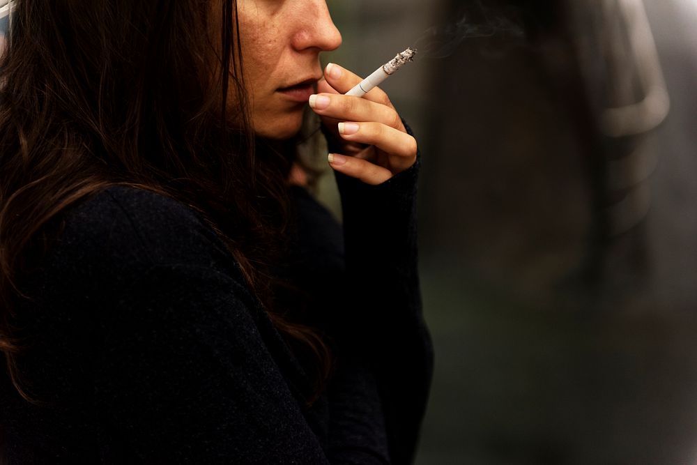Woman smoking cigarette alone