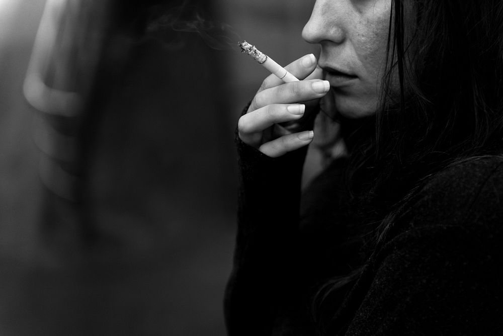 Woman smoking cigarette alone