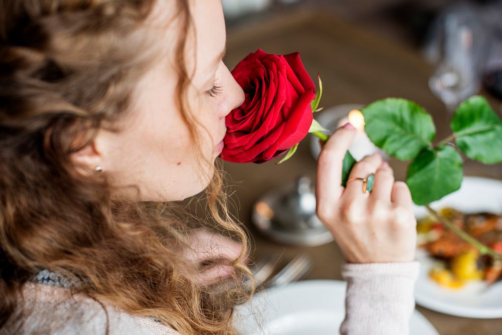 Woman holding flower and smelling it