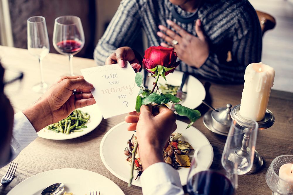 Man giving a rose and propose for the lady at dinner