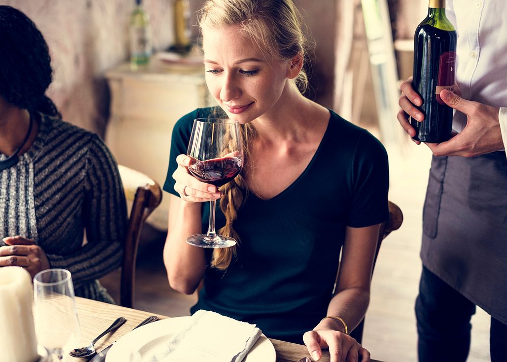Woman Tasting Red Wine in a Classy Restaurant