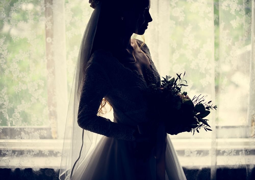 The bride holding bouquet in back lit