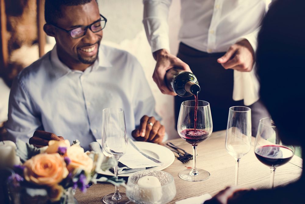 Restaurant Staff Poring Serving Red Wine to Customers