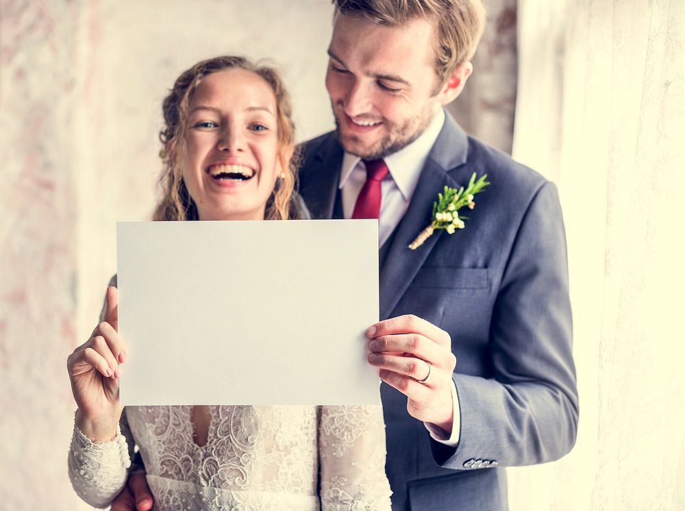 Bride and Groom Showing Blank Paper on Wedding Day