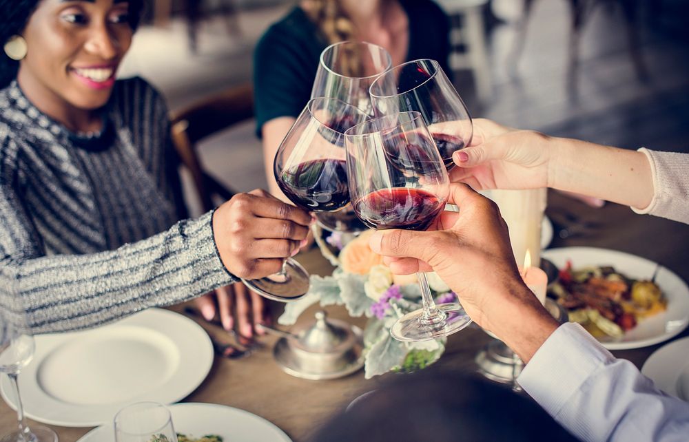 People Clinging Wine Glasses Together in Restaurant