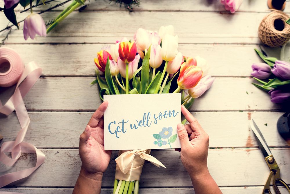 Hand Holding Show Get Well Soon Card with Tuips Flowers Backgrou