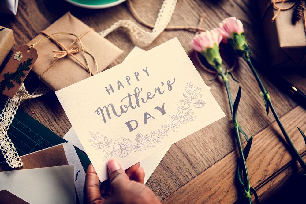 Hand Holding Show Happy Mother Day Card with Flowers Background