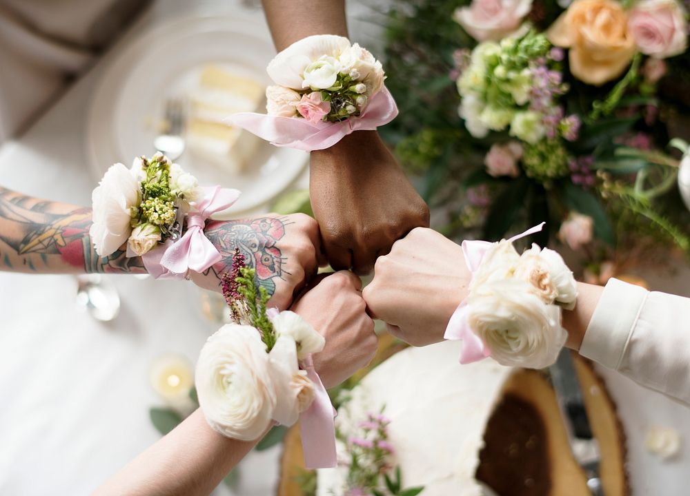 Bridesmaids party hands with corsage fists together