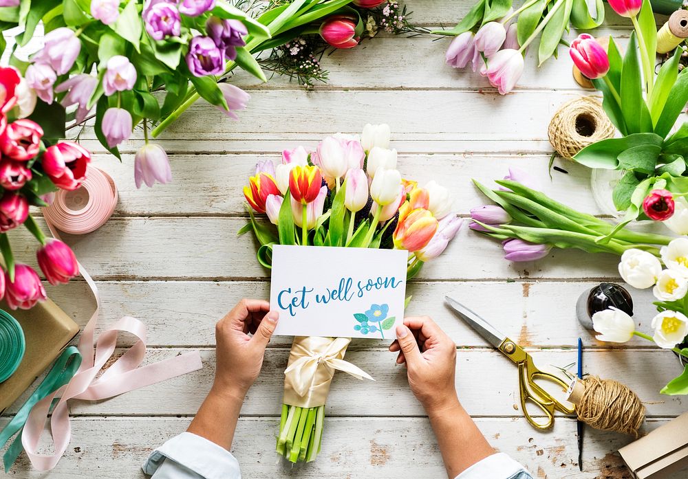 Hand Holding Show Get Well Soon Card with Flowers Background