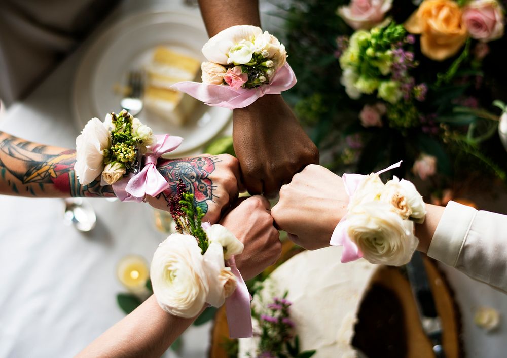 Bridesmaids party hands with corsage fists together
