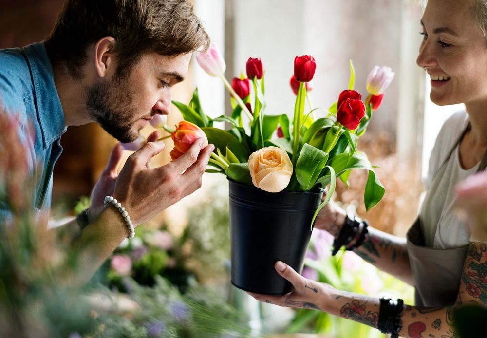 Man smelling fresh flowers in a pot