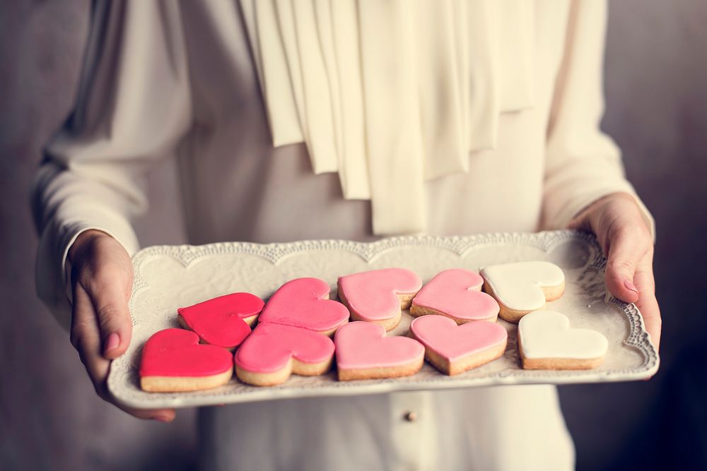Woman carry a plate of heart shaped sweet biscuit