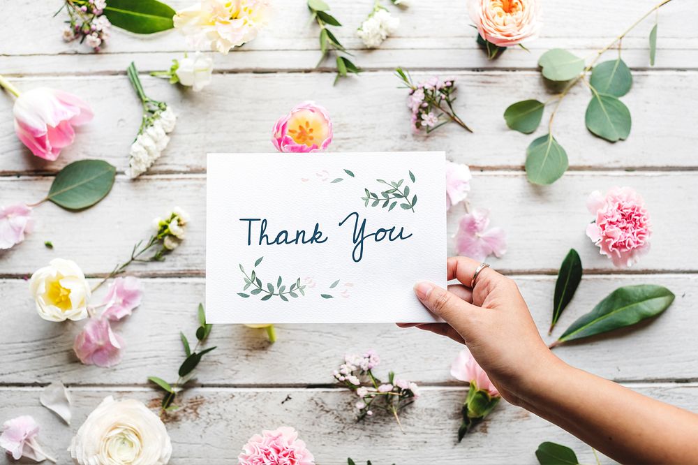 Hand Holding Show Thank You Card with Flowers Background