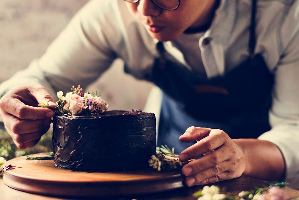 Baker Man Using Flowers Decorating Chocolate Cake