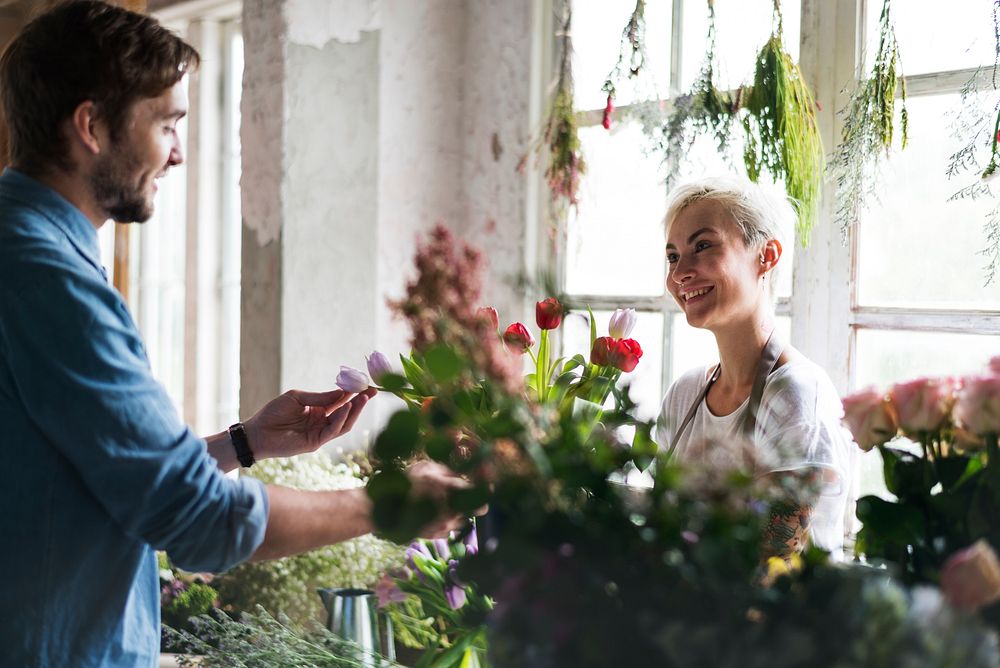 Flower shop owner talking with customer