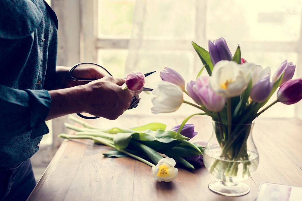 Florist woman decorates the flower on wooden table