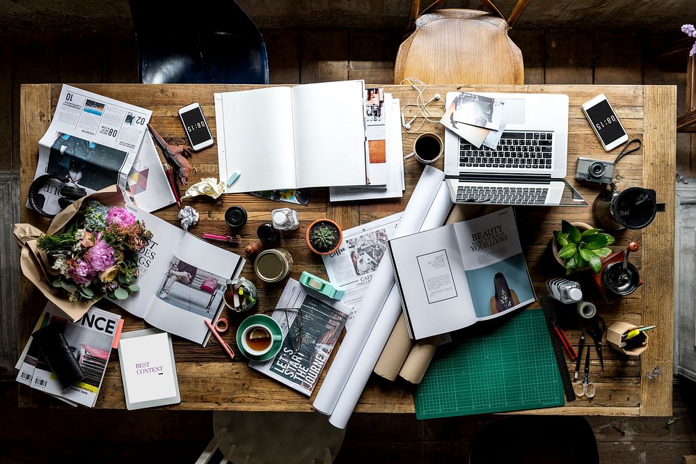 Designer messy workspace on wooden table