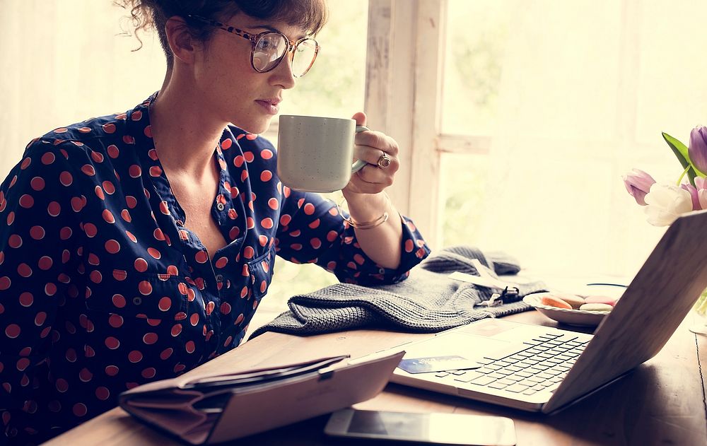 Woman Hands Holding Coffee Cup Working on Laptop
