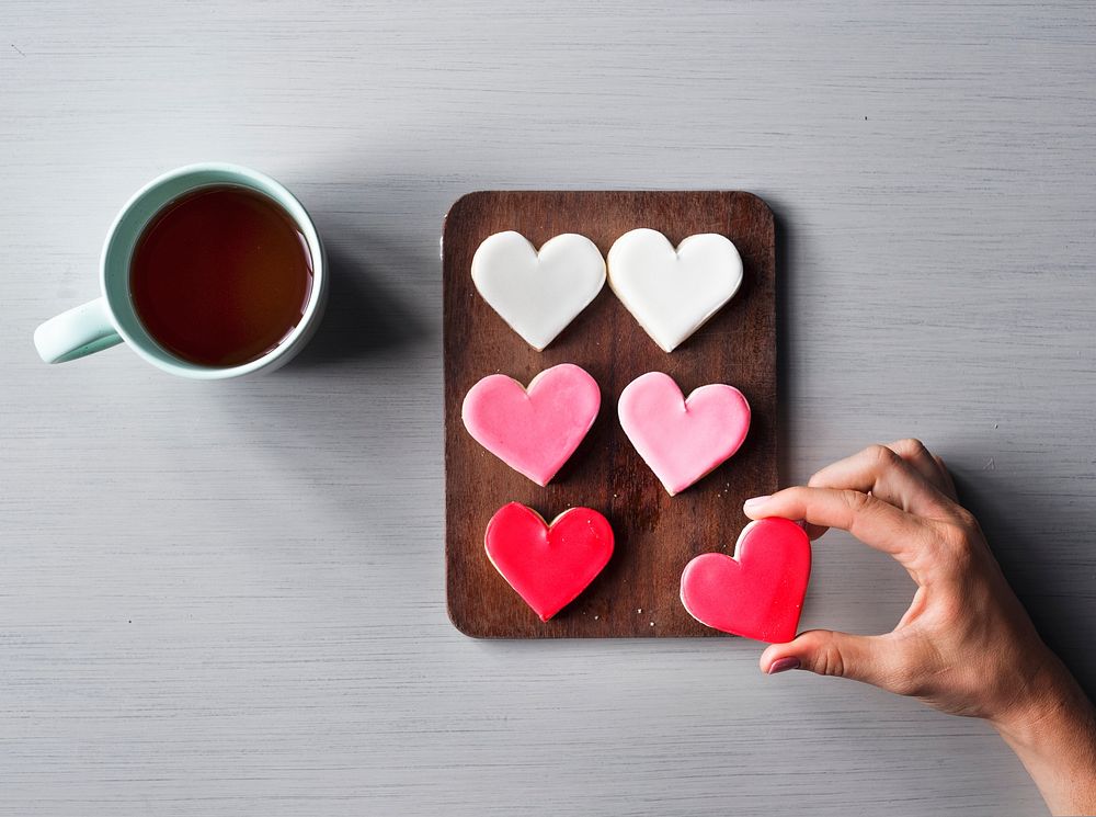 People Hands Showing Heart Shape Cookies with Coffee Cup