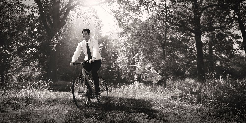 Businessman biking through a forest