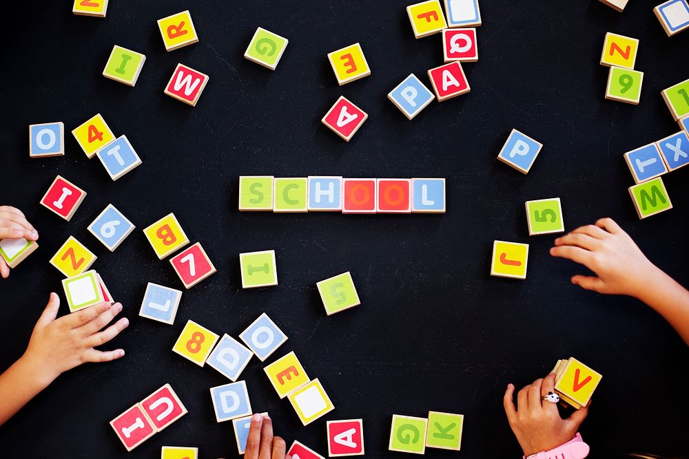 Kids spelling out words with alphabet blocks