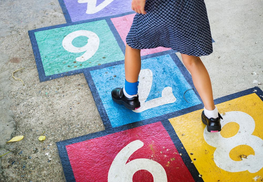 Kid playing hopscotch at school