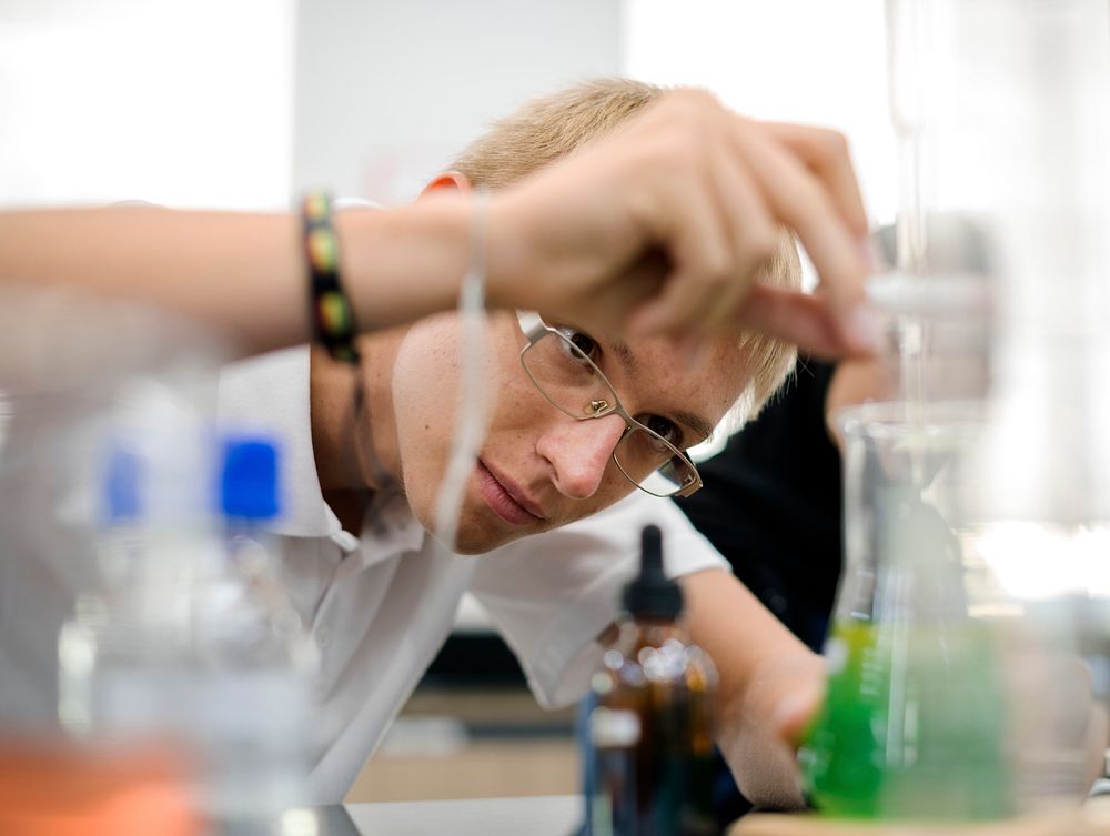 Male student doing a science experiment in the laboratory 